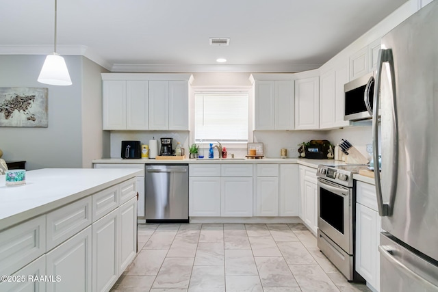 101 Barrow St, New Iberia, LA 70563 - kitchen with stainless steel appliances, ornamental molding, light countertops, white cabinetry, and light marble finish floors