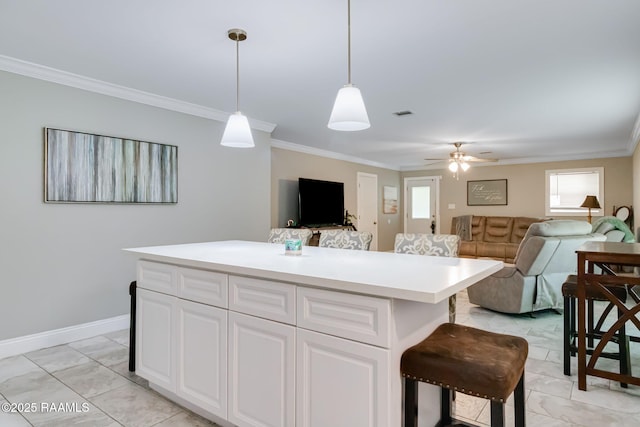 101 Barrow St, New Iberia, LA 70563 - kitchen with ornamental molding, light countertops, white cabinets, hanging light fixtures, and light marble finish floors