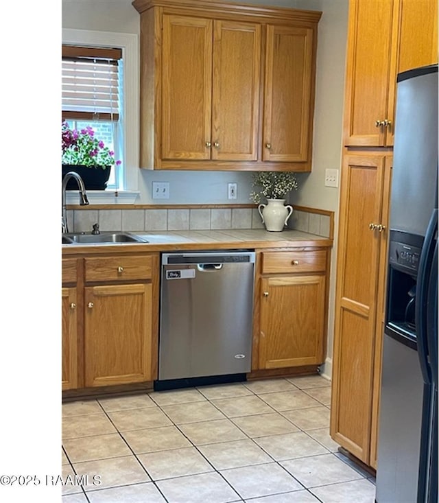 101 Asphodel Ct, Lafayette, LA 70503 - kitchen with stainless steel appliances, light tile patterned floors, brown cabinets, and tile counters