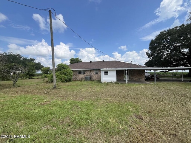 4702 Daspit Rd, New Iberia, LA 70563 - rear view of house with a lawn, a carport, and brick siding