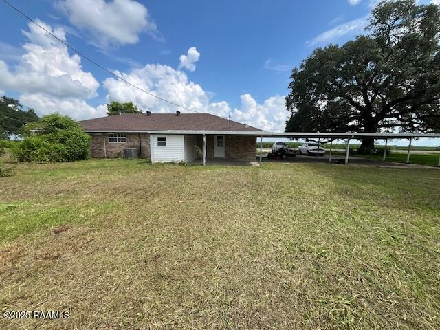 4702 Daspit Rd, New Iberia, LA 70563 - rear view of property featuring a yard and a carport