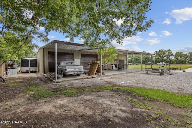 1054 Preston Broussard Rd, Arnaudville, LA 70512 - rear view of house featuring a garage, an outdoor structure, and dirt driveway