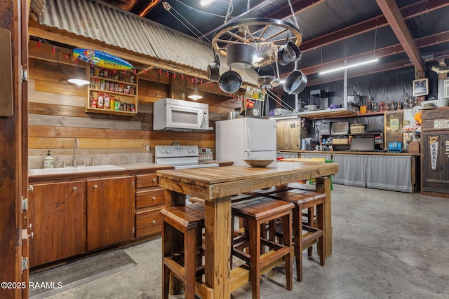 1054 Preston Broussard Rd, Arnaudville, LA 70512 - kitchen featuring white appliances, concrete flooring, open shelves, brown cabinetry, and wooden walls