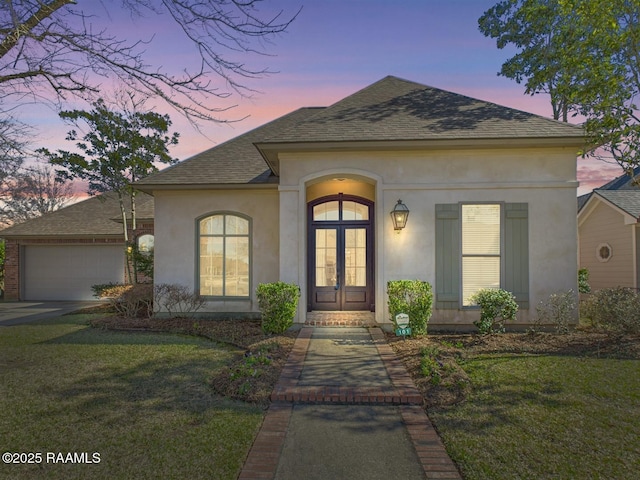 101 Lockeport Cir, Lafayette, LA 70508 - french country home featuring a shingled roof, french doors, stucco siding, and a garage