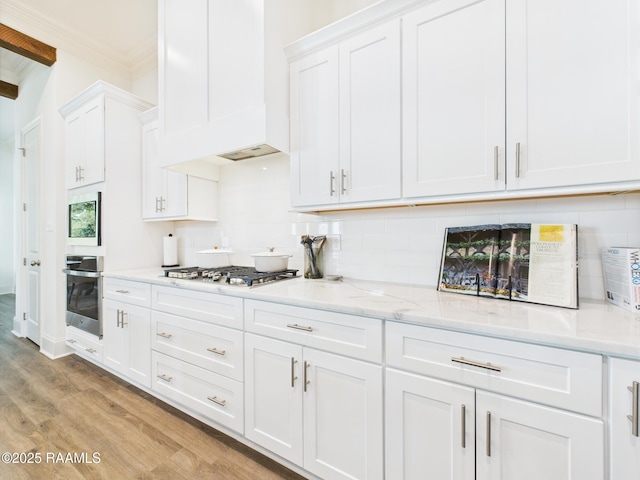 207 Timber Mill St, Lafayette, LA 70508 - kitchen with stainless steel appliances, tasteful backsplash, light wood finished floors, white cabinets, and ornamental molding