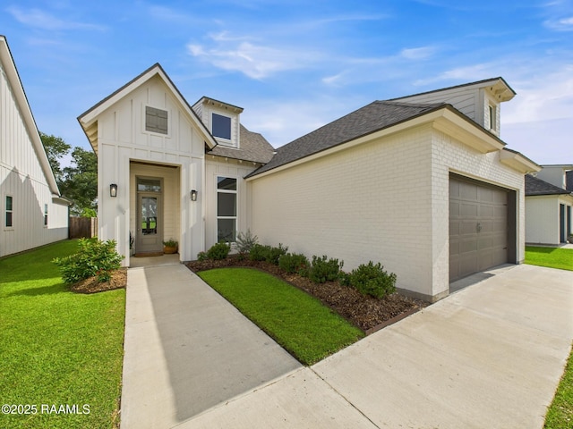 207 Timber Mill St, Lafayette, LA 70508 - view of front of home featuring a garage, concrete driveway, a front yard, board and batten siding, and brick siding