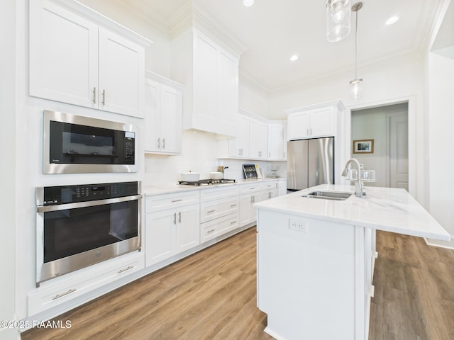 207 Timber Mill St, Lafayette, LA 70508 - kitchen featuring stainless steel appliances, crown molding, white cabinets, light wood finished floors, and hanging light fixtures