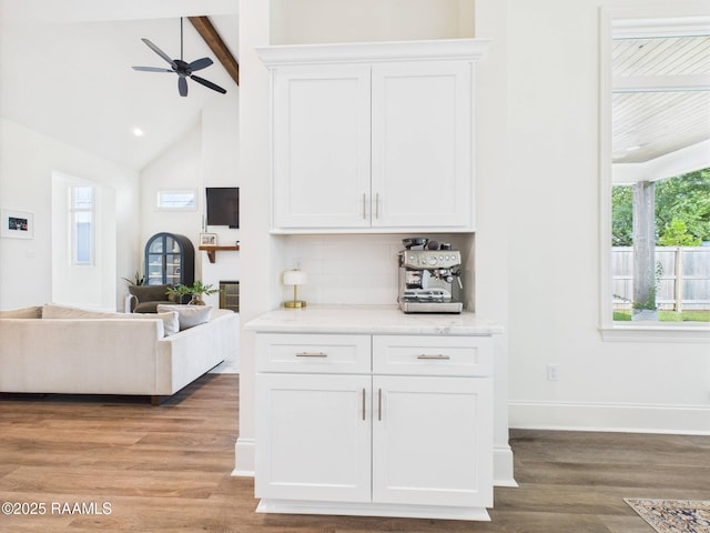 207 Timber Mill St, Lafayette, LA 70508 - kitchen featuring beamed ceiling, light wood-style floors, white cabinetry, decorative backsplash, and a ceiling fan