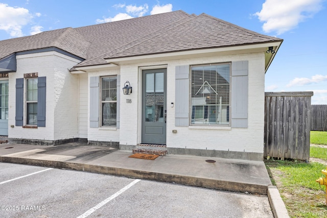 118 Rue Argenteuil, Lafayette, LA 70506 - view of exterior entry featuring roof with shingles, brick siding, and uncovered parking