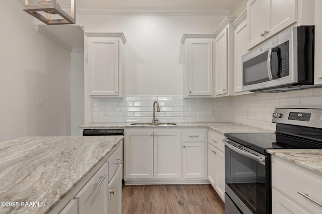 118 Rue Argenteuil, Lafayette, LA 70506 - kitchen featuring appliances with stainless steel finishes, crown molding, white cabinets, light stone counters, and decorative backsplash