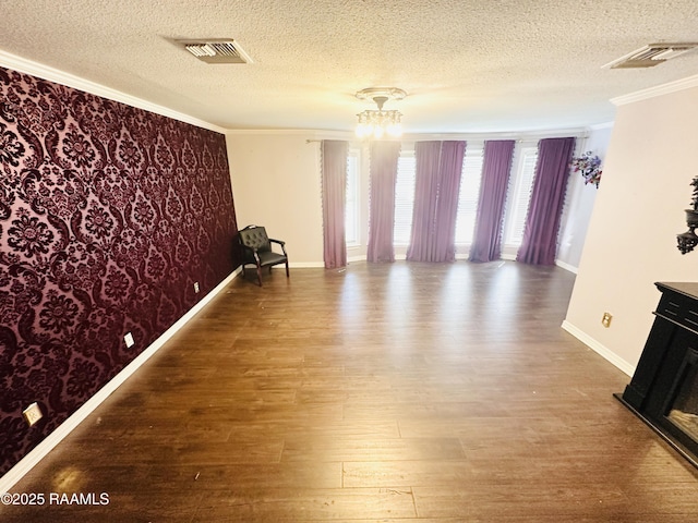 201 Edgewood Dr, Lafayette, LA 70503 - empty room featuring crown molding, wood finished floors, a textured ceiling, wallpapered walls, and a chandelier