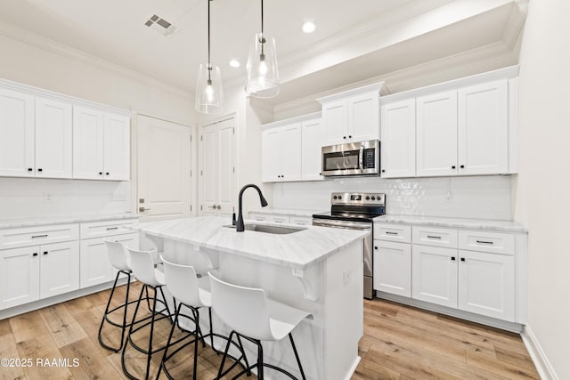 222 Alpine Dr, Lafayette, LA 70506 - kitchen featuring stainless steel appliances, crown molding, a kitchen breakfast bar, a kitchen island with sink, and tasteful backsplash
