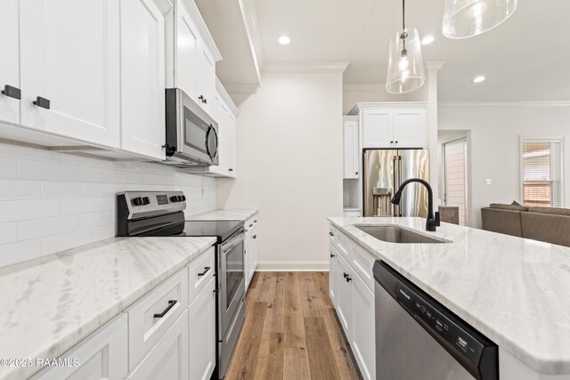 222 Alpine Dr, Lafayette, LA 70506 - kitchen with appliances with stainless steel finishes, crown molding, light wood finished floors, white cabinets, and recessed lighting