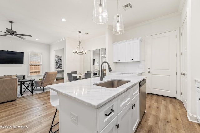 222 Alpine Dr, Lafayette, LA 70506 - kitchen with crown molding, open floor plan, a kitchen breakfast bar, light wood-style flooring, and white cabinets