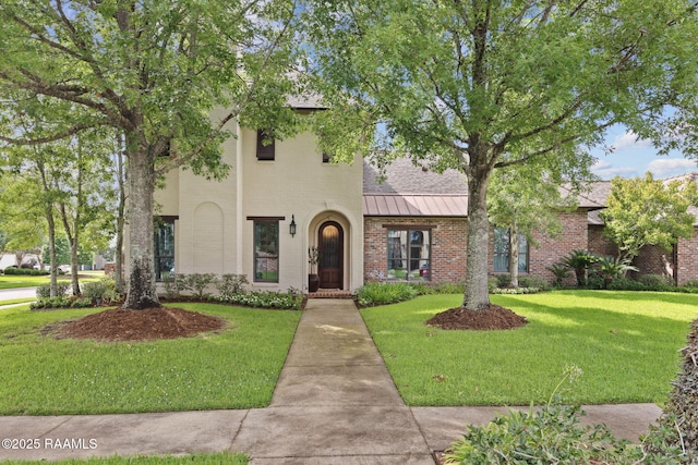 101 Enclave Ct, Lafayette, LA 70508 - view of front of home featuring a standing seam roof, brick siding, a front lawn, and a metal roof