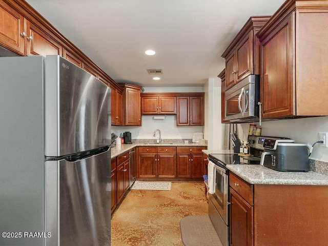 1166 Madeline Hts, Breaux Bridge, LA 70517 - kitchen with stainless steel appliances, recessed lighting, concrete flooring, light stone counters, and brown cabinets