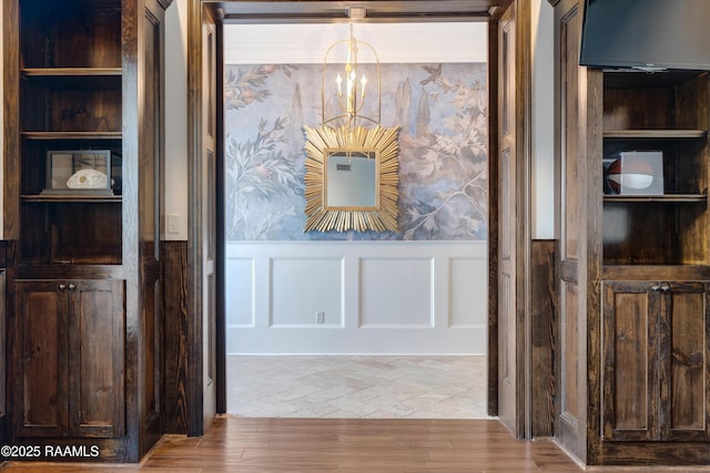 506 Terrell Ct, New Iberia, LA 70563 - detailed view of a chandelier, a wainscoted wall, a decorative wall, built in features, and wood finished floors
