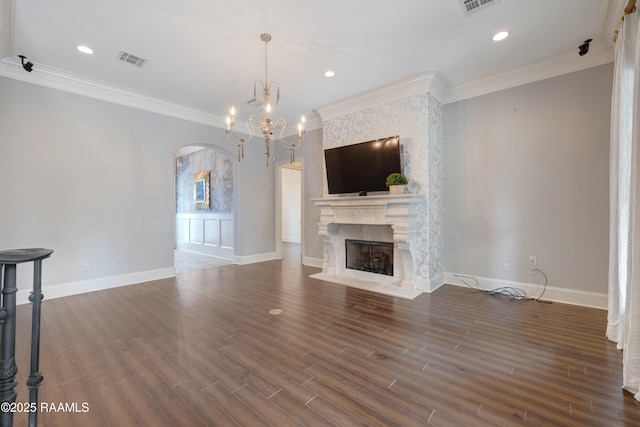 506 Terrell Ct, New Iberia, LA 70563 - unfurnished living room featuring arched walkways, a fireplace, ornamental molding, dark wood-style flooring, and a chandelier