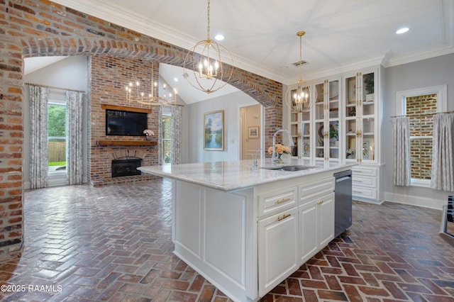 506 Terrell Ct, New Iberia, LA 70563 - kitchen with a chandelier, brick flooring, a brick fireplace, stainless steel dishwasher, and recessed lighting