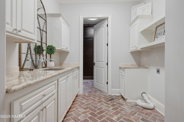 506 Terrell Ct, New Iberia, LA 70563 - laundry room featuring electric dryer hookup, brick floors, and cabinet space