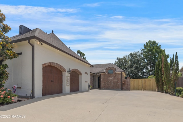 506 Terrell Ct, New Iberia, LA 70563 - view of home's exterior with concrete driveway, an attached garage, roof with shingles, and brick siding