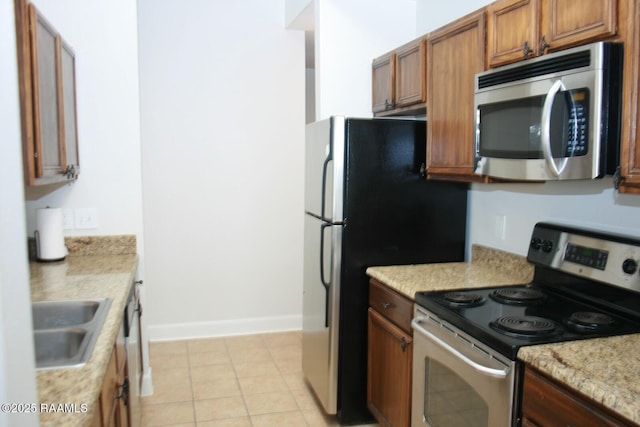 201 Settlers Trace Blvd Unit 2410, Lafayette, LA 70508 - kitchen with appliances with stainless steel finishes, brown cabinets, and light tile patterned floors