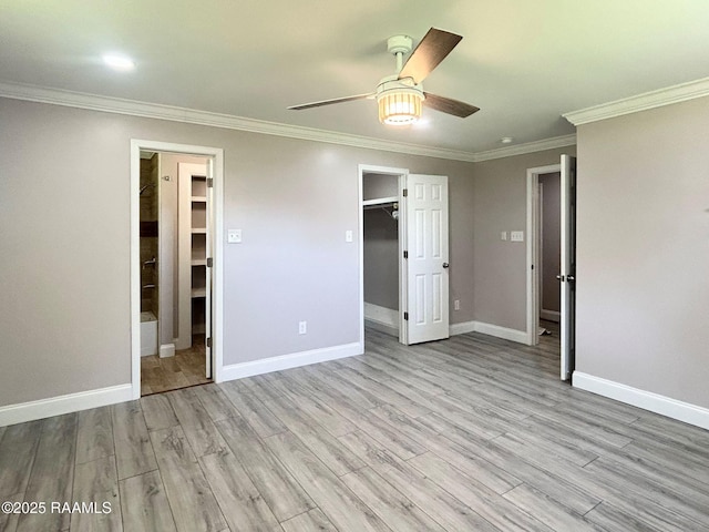 104 E Coleman St, Opelousas, LA 70570 - unfurnished bedroom with ornamental molding, light wood-type flooring, a spacious closet, ensuite bath, and ceiling fan