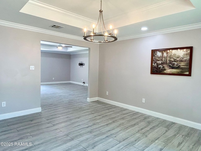 104 E Coleman St, Opelousas, LA 70570 - spare room featuring a raised ceiling, ornamental molding, a chandelier, and light wood-style floors