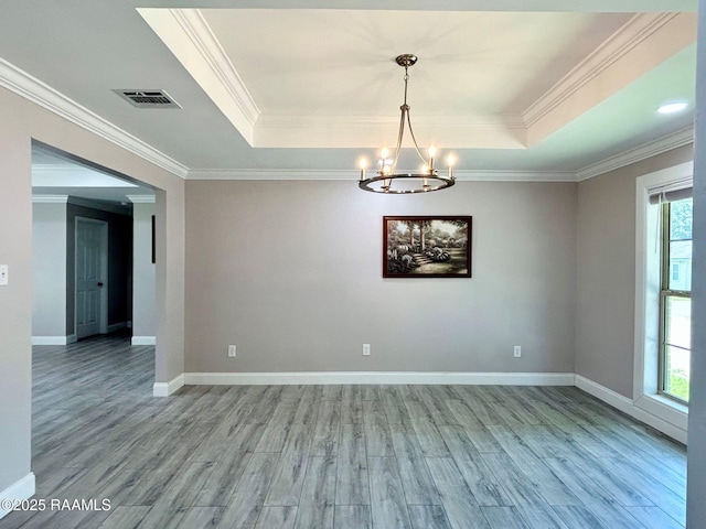 104 E Coleman St, Opelousas, LA 70570 - empty room featuring a tray ceiling, light wood-type flooring, a chandelier, and crown molding