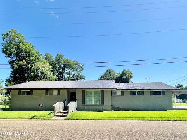 104 E Coleman St, Opelousas, LA 70570 - single story home featuring brick siding, a front lawn, and a metal roof