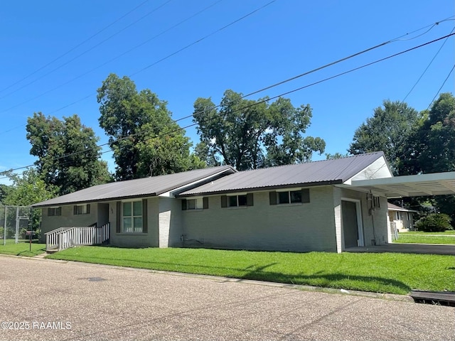 104 E Coleman St, Opelousas, LA 70570 - ranch-style home with an attached carport, a front lawn, a metal roof, and brick siding