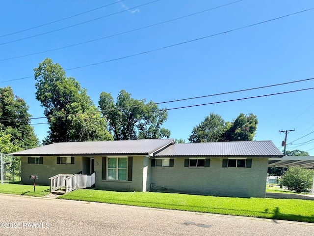 104 E Coleman St, Opelousas, LA 70570 - ranch-style house featuring brick siding, a front lawn, and a metal roof