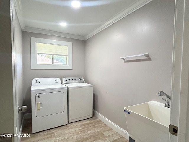 104 E Coleman St, Opelousas, LA 70570 - laundry area with washing machine and clothes dryer, crown molding, and light wood-type flooring