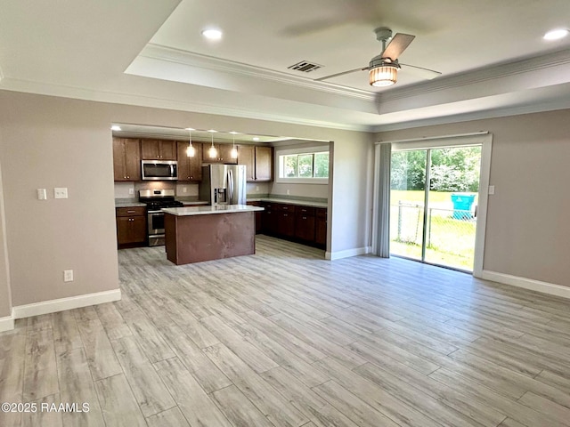 104 E Coleman St, Opelousas, LA 70570 - kitchen featuring appliances with stainless steel finishes, a tray ceiling, ornamental molding, open floor plan, and ceiling fan