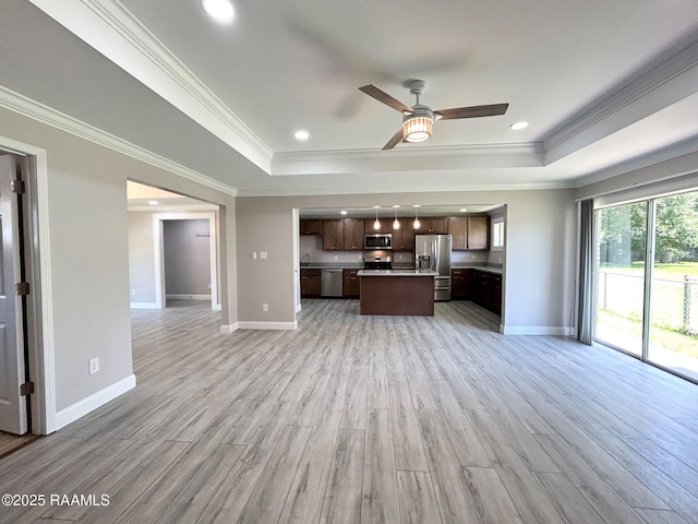 104 E Coleman St, Opelousas, LA 70570 - unfurnished living room with a raised ceiling, crown molding, light wood finished floors, a ceiling fan, and recessed lighting