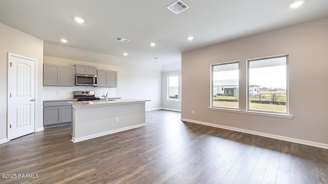 322 White Pine Dr, Lafayette, LA 70501 - kitchen with gray cabinets, appliances with stainless steel finishes, dark wood finished floors, light countertops, and a kitchen island with sink