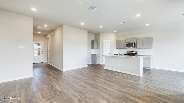 322 White Pine Dr, Lafayette, LA 70501 - kitchen with gray cabinets, appliances with stainless steel finishes, light countertops, light wood-style floors, and a kitchen island with sink