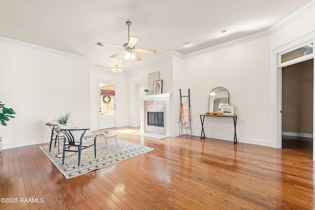 105 Clear Lake Dr, Lafayette, LA 70506 - unfurnished living room featuring a ceiling fan, hardwood / wood-style flooring, ornamental molding, and a tiled fireplace