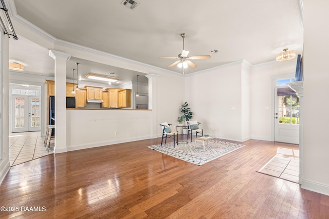 105 Clear Lake Dr, Lafayette, LA 70506 - unfurnished living room with healthy amount of natural light, hardwood / wood-style flooring, a ceiling fan, crown molding, and decorative columns