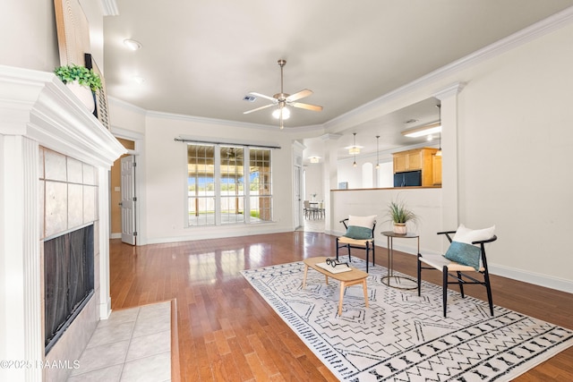 105 Clear Lake Dr, Lafayette, LA 70506 - living area with a tiled fireplace, ceiling fan, light wood-type flooring, and ornamental molding