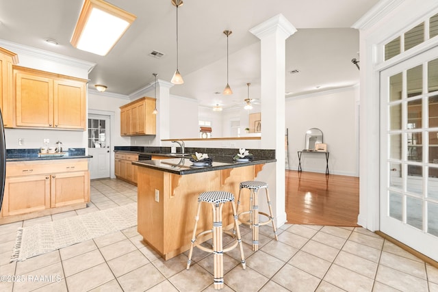 105 Clear Lake Dr, Lafayette, LA 70506 - kitchen with light tile patterned flooring, light brown cabinets, a kitchen breakfast bar, crown molding, and a peninsula