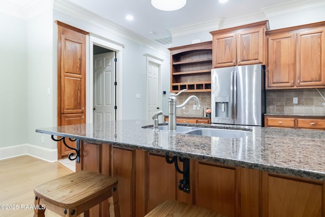 100 Serenity Sound Dr, Lafayette, LA 70506 - kitchen featuring stainless steel fridge, backsplash, dark stone countertops, open shelves, and brown cabinets