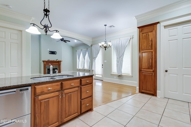 100 Serenity Sound Dr, Lafayette, LA 70506 - kitchen with dishwasher, a chandelier, brown cabinetry, ceiling fan, and dark stone counters