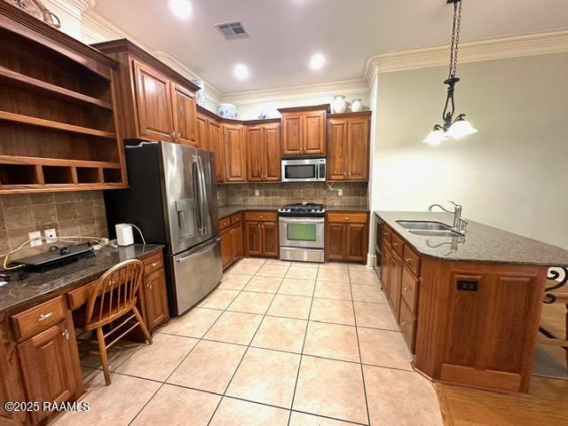 100 Serenity Sound Dr, Lafayette, LA 70506 - kitchen featuring stainless steel appliances, crown molding, brown cabinetry, a peninsula, and light tile patterned floors