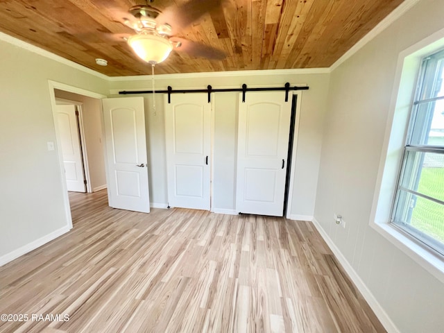 5501 Northside Rd, New Iberia, LA 70563 - unfurnished bedroom with wooden ceiling, a barn door, crown molding, light wood-style flooring, and a closet