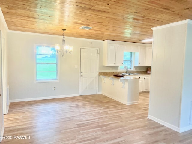 5501 Northside Rd, New Iberia, LA 70563 - kitchen featuring wooden ceiling, a peninsula, ornamental molding, healthy amount of natural light, and white cabinetry