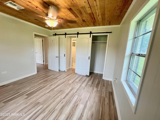 5501 Northside Rd, New Iberia, LA 70563 - unfurnished bedroom featuring crown molding, wooden ceiling, a barn door, light wood finished floors, and a closet