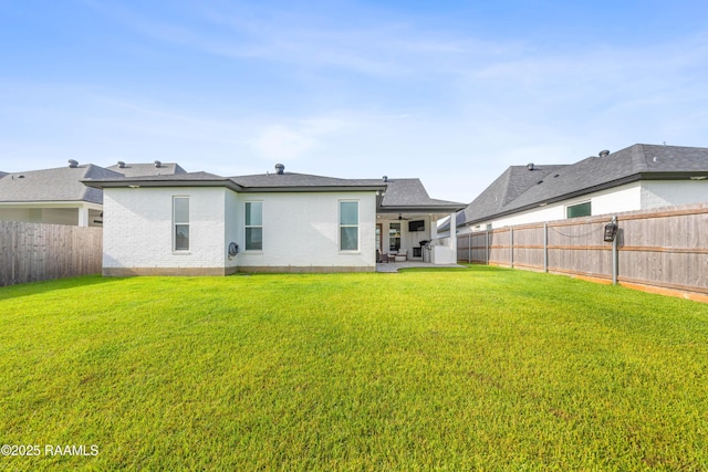 127 Lakes Edge Dr, Broussard, LA 70518 - rear view of house with a fenced backyard, brick siding, and a patio area