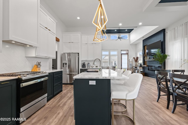 127 Lakes Edge Dr, Broussard, LA 70518 - kitchen with appliances with stainless steel finishes, tasteful backsplash, white cabinets, light stone counters, and light wood-type flooring