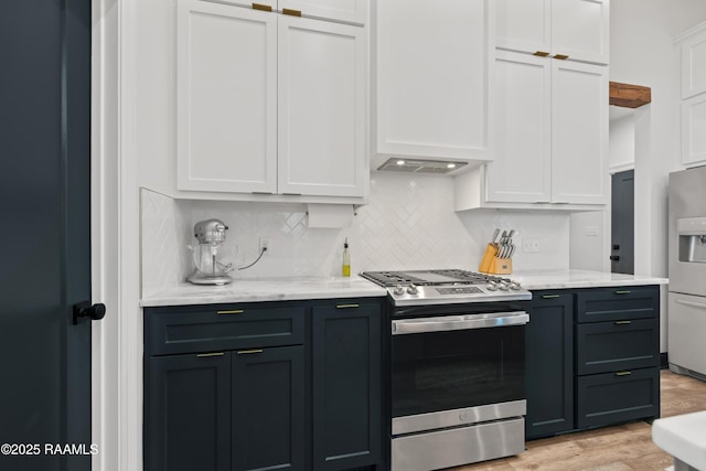 127 Lakes Edge Dr, Broussard, LA 70518 - kitchen with stainless steel gas stove, white cabinets, decorative backsplash, light wood-type flooring, and fridge with ice dispenser